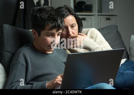 Gemeinsam zu Hause lernen, -Mutter hilft Sohn bei der Schularbeit Stockfoto