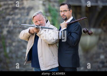 Grevenbroich, Deutschland. Juni 2020. Jan Josef Liefers (r), Schauspieler, (als Karl-Friedrich Boerne) mit einem Morgenstern mit zwei Metallkugeln und Axel Prahl, Schauspieler, (als Frank Thiel) mit Armbrust, stehen bei den Dreharbeiten zum neuen Münsteraner Tatort vor Schloss Hülchrath. Ein Sendetermin für den Tatort mit dem Titel "lang lebe der König" in der ARD ist noch nicht festgelegt. Quelle: Rolf Vennenbernd/dpa/Alamy Live News Stockfoto
