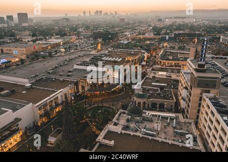 Das Grove Einkaufszentrum in Los Angeles bei Sonnenuntergang mit Geschäften und Hollywood Skyline in der Ferne Stockfoto