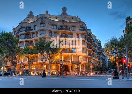 Dämmerungsszene von Casa Mila (oder La Pedrera), einem der berühmtesten Werke von Antoni Gaudi im Stadtteil Eixample von Barcelona, Spanien. Stockfoto