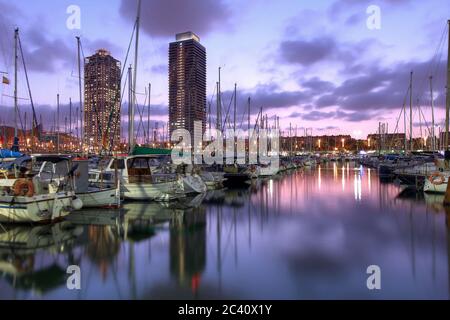 Zwillingshochhäuser überragen den Yachthafen in Port Olimpic (Olympischer Hafen), Barcelona, Spanien bei Sonnenuntergang. Stockfoto