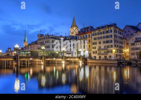 Dämmerungsszene in Zürich, Schweiz mit der Altstadt, die sich im Wasser der Limmat spiegelt, während sie in den Zürichsee fließt. Stockfoto