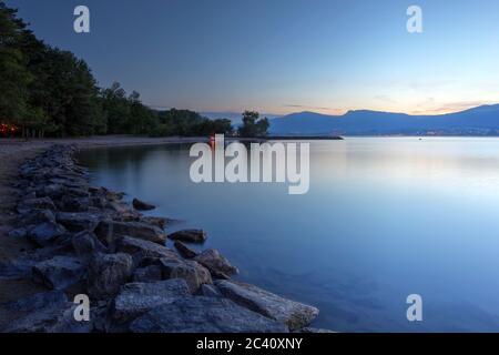 Sonnenuntergangslandschaft des Neuchatelsees in der Schweiz, am Strand von Yvonand. Stockfoto