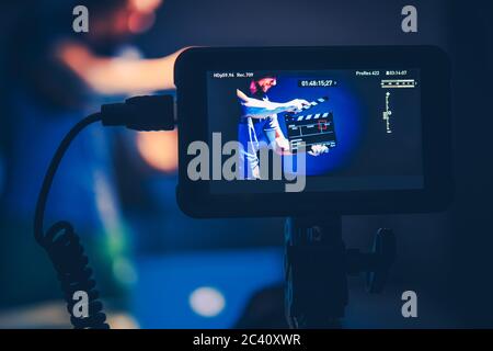 Videografie Thema mit Kamera-Operator Shoots von Männern mit Clapperboard. Nahaufnahme Des Videoanzeige-Monitors. Motion Picture Technologie. Stockfoto