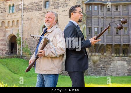 Grevenbroich, Deutschland. Juni 2020. EXKLUSIV - Jan Josef Liefers (r), Schauspieler, (als Karl-Friedrich Boerne) mit Morgenstern mit zwei Metallkugeln und Axel Prahl, Schauspieler, (als Frank Thiel) mit Armbrust, stehen vor Schloss Hülchrath während der Dreharbeiten zum neuen Tatort aus Münster. Ein Sendetermin für den Tatort mit dem Titel "Long Live The King" in der ARD ist noch nicht festgelegt. Quelle: Rolf Vennenbernd/dpa/Alamy Live News Stockfoto