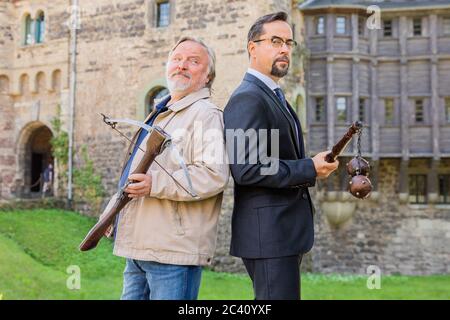 Grevenbroich, Deutschland. Juni 2020. EXKLUSIV - Jan Josef Liefers (r), Schauspieler, (als Karl-Friedrich Boerne) mit Morgenstern mit zwei Metallkugeln und Axel Prahl, Schauspieler, (als Frank Thiel) mit Armbrust, stehen vor Schloss Hülchrath während der Dreharbeiten zum neuen Tatort aus Münster. Ein Sendetermin für den Tatort mit dem Titel "Long Live The King" in der ARD ist noch nicht festgelegt. Quelle: Rolf Vennenbernd/dpa/Alamy Live News Stockfoto