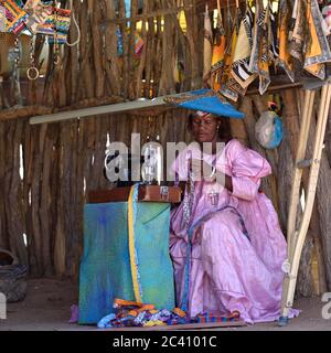 KAOKOLAND, NAMIBIA - 1. FEB 2016: Unbekannte Herero-Frau in traditioneller Kleidung mit Nähmaschine. Die Herero, die zur Bantu Gruppe gehören, mit Stockfoto