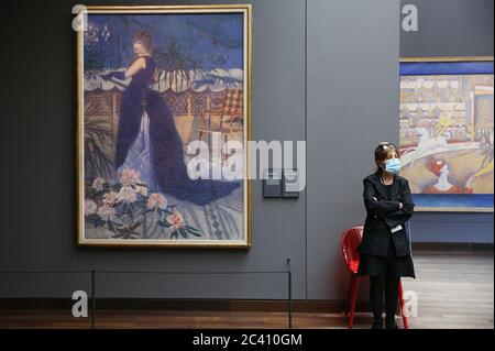 Paris, Frankreich. Juni 2020. Ein Mitarbeiter mit einer schützenden Gesichtsmaske steht neben Kunstwerken im Musée d'Orsay, als das Museum am 23. Juni 2020 in Paris, Frankreich, wieder für die Öffentlichkeit zugänglich ist. Das Musée d'Orsay (Museum Orsay) öffnete seine Türen am Dienstag nach seiner Schließung wieder für die Öffentlichkeit, als Frankreich in eine neue Phase der Entbindung mit weiteren Maßnahmen zur Lockerung des Coronavirus-Sperrens eingetreten war. Kredit: Gao Jing/Xinhua/Alamy Live Nachrichten Stockfoto