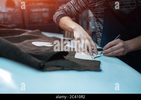 Mann formt Leder für Schuh mit Messer auf Fabrik Stockfoto