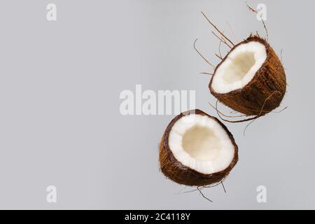 Frische reife Kokosnuss in der Luft isoliert auf pastellgrauem Hintergrund. Stockfoto