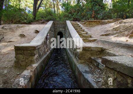 Eingang zum Tunnel auf dem Loutanis Fluss in Seven Spring (Epta Piges) im Wald bei Kolymbia (Rhodos, Griechenland) Stockfoto