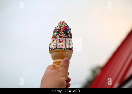 Ein Eiskegel mit Streuseln in der Hand Stockfoto