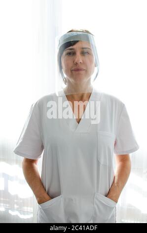 Krankenschwester trägt einen Gesichtsschutz und eine weiße Jacke Stockfoto
