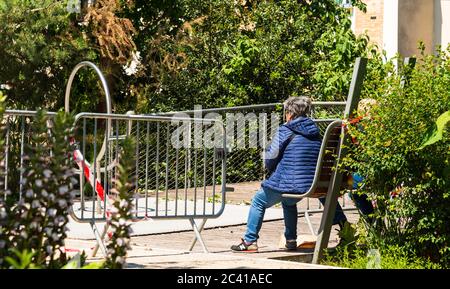 Paris, Frankreich - 15. Mai 2020: Senioren-Paar sitzt auf der Bank vor dem geschlossenen Park in Pariser Vorort. Coronavirus-Lockdown-Ende Stockfoto