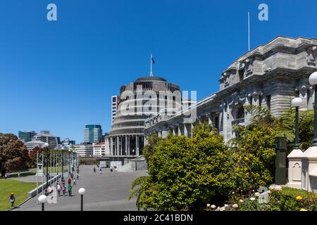 Wellington, Neuseeland: Die 'Beehive' (links) ist der gebräuchliche Name für den Exekutivflügel des neuseeländischen Parlamentsgebäudes (rechts) Stockfoto