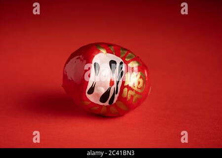 Daruma Puppe auf rotem Hintergrund, japanische Puppe Stockfoto