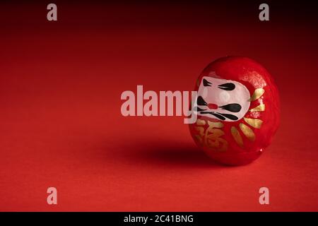 Daruma Puppe auf rotem Hintergrund, japanische Puppe Stockfoto