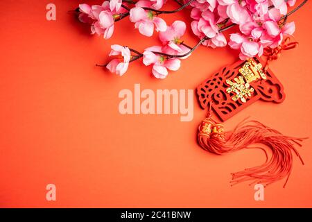 Hintergrund zum chinesischen Neujahr. Chinesische Ornamente und rosa Blume. Das Wort auf dem Ornament ist chinesisches Wort, das „viel Glück“ bedeutet. Stockfoto