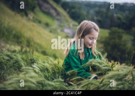 Kind spielt in Tall Grass auf einem Hügel in Belgrad, Serbien Stockfoto