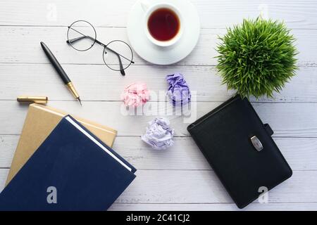Journalistentisch mit Notizbuch, zerknittertes Papier auf weißem Hintergrund. Stockfoto