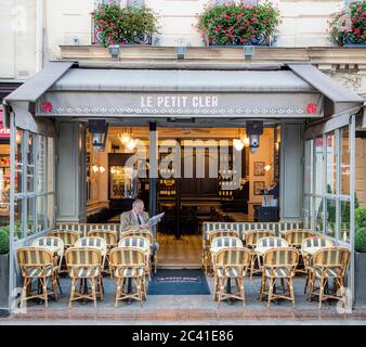 Mann liest Zeitung im Le Petit Cler - Café in der Rue Cler im 7. Arrondissement, Paris, Frankreich Stockfoto