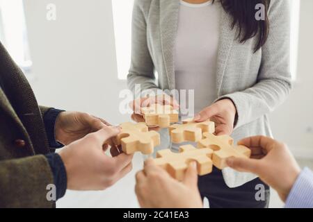 Gesichtslose Geschäftsleute, die Puzzles zusammenfügen Stockfoto