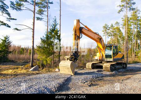 Gelbe Bagger Bau einer Straße tief im Wald. Rusko, Finnland. Stockfoto