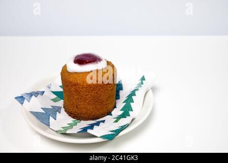 Runebergs Kuchen ist ein finnisches Gebäck, das mit Mandeln und Arrack oder Rum gewürzt ist. Es hat normalerweise Himbeerbenstau, der oben von einem Ring aus Eisbildung umkreist wird. Stockfoto