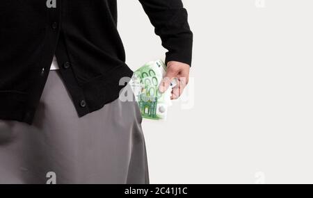 Die Hand der Frau bekommt Geld aus Taschen in ihrer Kleidung. Die weiblichen Hände halten Euro. Stockfoto