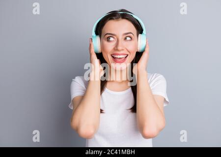 Portrait of content verträumte Mädchen Jugend haben schnurlose Headset fühlen Vergnügen aufgeregt Look Copyspace tragen lässige Stil Kleidung isoliert über graue Farbe Stockfoto