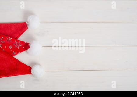 Set von roten weihnachtsmann-Hüte auf weißem Holzhintergrund mit Kopierraum. Für Weihnachtsverkäufe. Neujahr und Weihnachten. Stockfoto