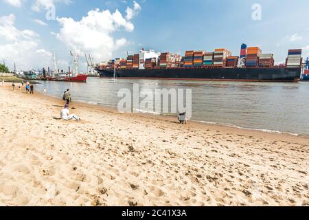 Stadtstrand in Hamburg, Deutschland mit großem Containerschiff im Hintergrund Stockfoto