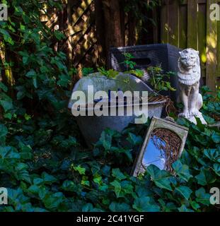 Von Ivy überwuchert Garten Ornamente im Hinterhof Stockfoto