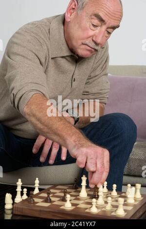 Alter Mann spielt Schach Stockfoto