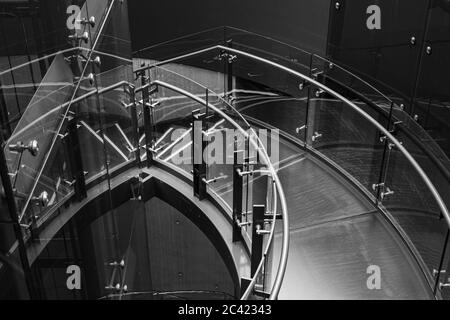 Schwarz-weiß Bild einer absteigenden Treppe aus Stahl und Glas im Telus-Gebäude in Vancouver, British Columbia Stockfoto