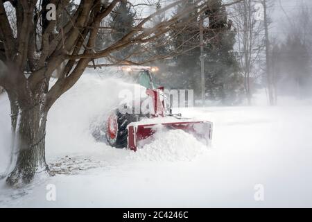 Schneefräse, die während des Schneesturms von der Einfahrt Schnee bläst, Meaford, Ontario, Kanada Stockfoto