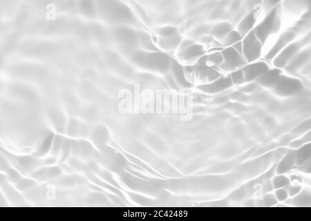 Nahaufnahme der entsättigte transparente klare ruhige Wasseroberfläche Textur mit Spritzern und Blasen. Trendy abstrakt Natur Hintergrund. Stockfoto