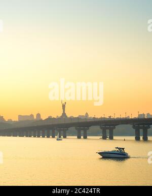 Anzeigen von Mutter Heimat Denkmal, Motorboot auf Dnipro River, Paton Brücke. Kiew, Ukraine Stockfoto