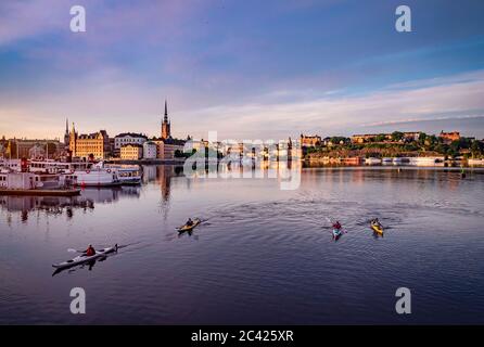 Stockholm, Schweden - 23. Jun 2020: Blick auf die Insel Riddarholmen und Sodermalm. Aktive Kajaker paddeln im Vordergrund Stockfoto