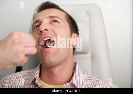 Junger Mann mit Zahnuntersuchung Stockfoto