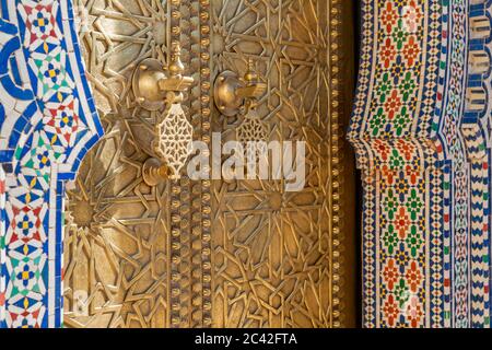 Messing Türklopfer und Mosaiken des königlichen Palastes in Fès. Die hölzernen Tore der Mauer um den königlichen Palast zwischen 1961 und 1968 sind mit Messingarbeiten verziert Stockfoto