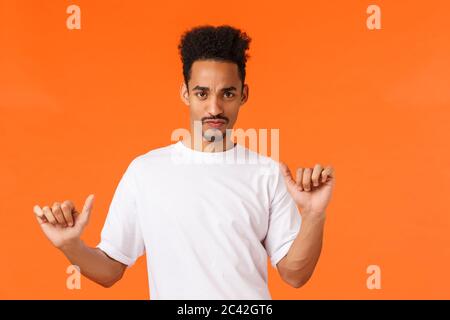 Kerl fühlt Partystimmung. Groovie und frech sorgenfreier sassiger afroamerikanischer Hiphster in weißem T-Shirt tanzen, bewegen und Musik genießen Stockfoto