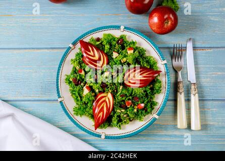 Grüner Grünkohl-Salat mit rotem Apfel, Preiselbeere und Sonnenblumenkernen. Gesundes Lebensmittelkonzept. Stockfoto