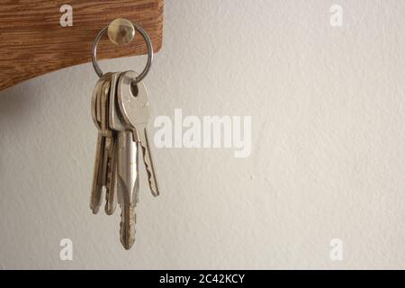 Schlüsselbund, der an einem Halter an einer weißen Wand hängt Stockfoto