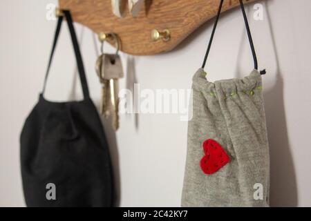 Masken hängen an der Wand neben den Schlüsseln, als neue Tagesartikel zu verwenden, weil COVID-19 Stockfoto