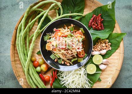 Thai-Essen von oben, Papaya-Salat würzig mit Yardlong Bohnenkräuter und Gewürze Zutaten Chili-Tomate Erdnuss Knoblauch serviert auf dem Tisch Stockfoto