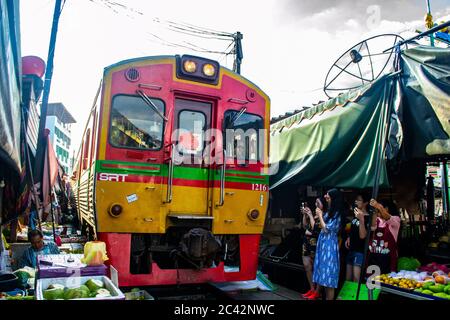 MAEKLONG/THAILAND-NOVEMBER 28 2019: Zug durch Maeklong Bahnmarkt - eine berühmte Touristenattraktion direkt außerhalb von Bangkok Stockfoto