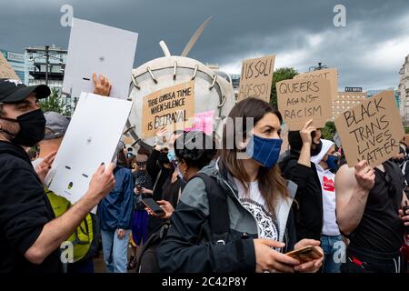 Menschen mit Plakaten über Schweigen als Verrat, Queer und Trans Black Leben während der Protestversammlung in Solidarität mit der BLM-Bewegung. Stockfoto