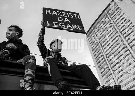 Protestler hält Plakat mit den Worten "Razzisti da Legare"während der Protestversammlung in Solidarität mit der BLM-Bewegung.Pirelli Turm im Hintergrund Stockfoto