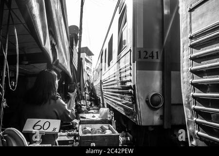 MAEKLONG/THAILAND-NOVEMBER 28 2019: Zug durch Maeklong Bahnmarkt - eine berühmte Touristenattraktion direkt außerhalb von Bangkok Stockfoto